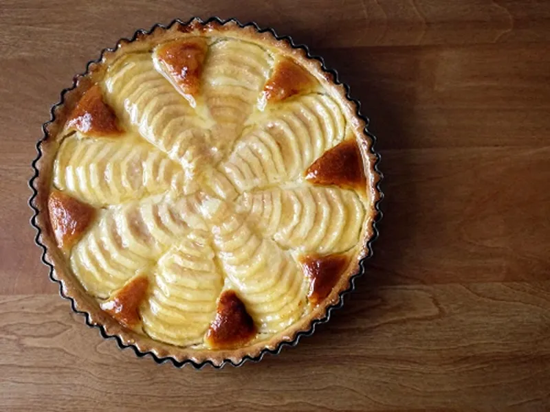 A bowl of spiced pear and almond tart, a delightful dessert for Christmas dinner for vegetarians.