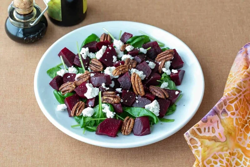 A plate of goat's cheese and beetroot salad, a fresh option for Christmas dinner starters ideas.