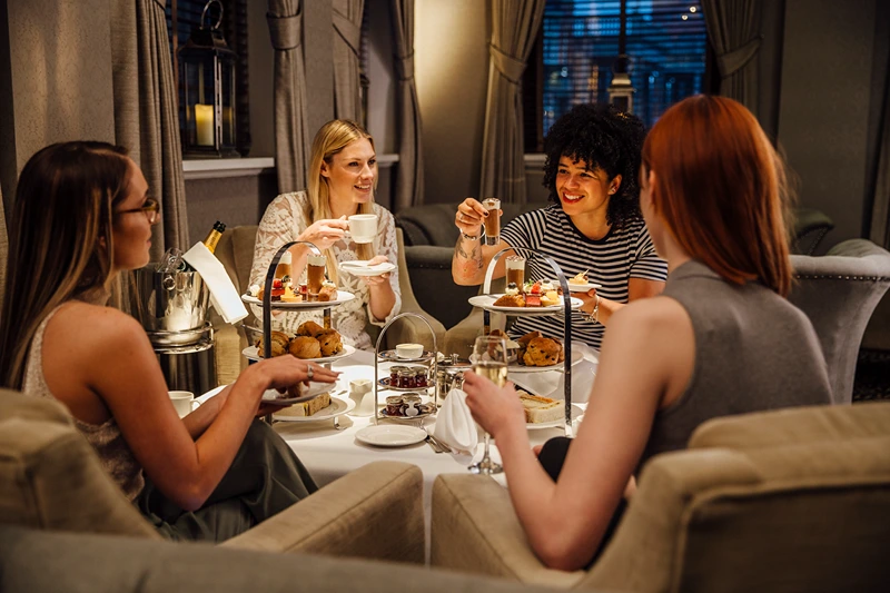 Four women enjoying an afternoon tea, one of classy hen party ideas Birmingham offers.