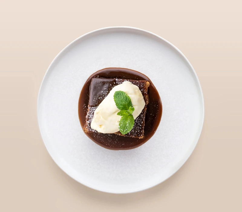 Plated sticky treacle toffee pudding, a rich option for vegetarian Christmas desserts.