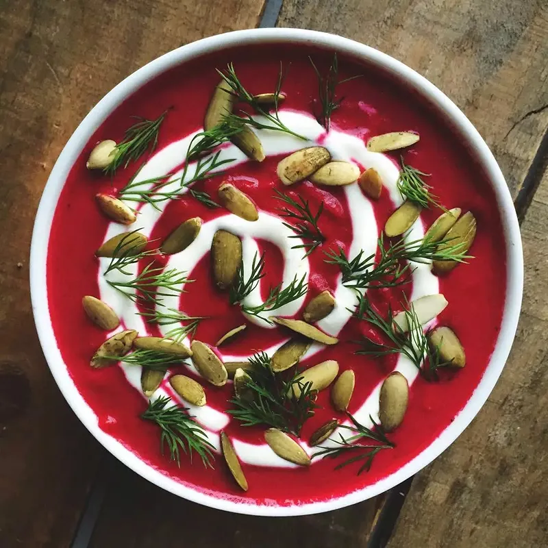 A bowl of beetroot and apple soup with horseradish cream, ideal for vegetarian Christmas starters.