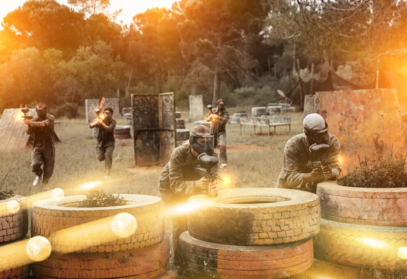 Group of men playing paintball, showcasing 21st boy birthday ideas