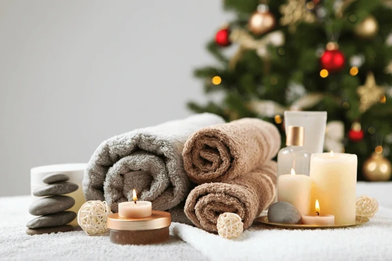 Spa towels and candles spread out on a table, suggesting Christmas ideas for your girlfriend.
