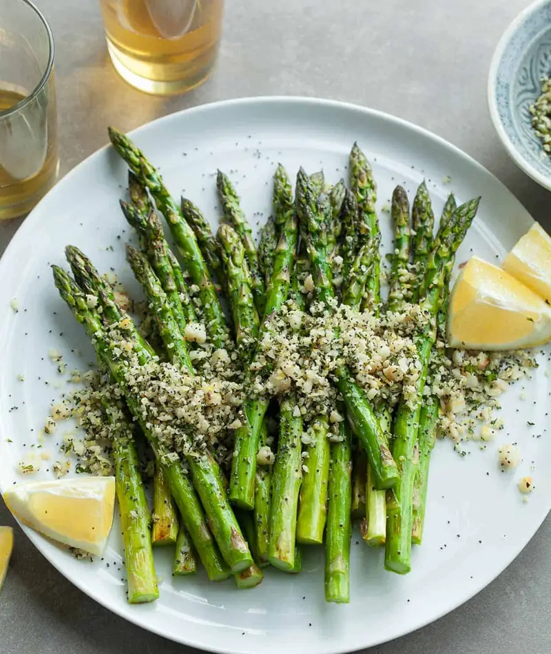 Grilled asparagus with lemon butter on a plate for NYE food idea