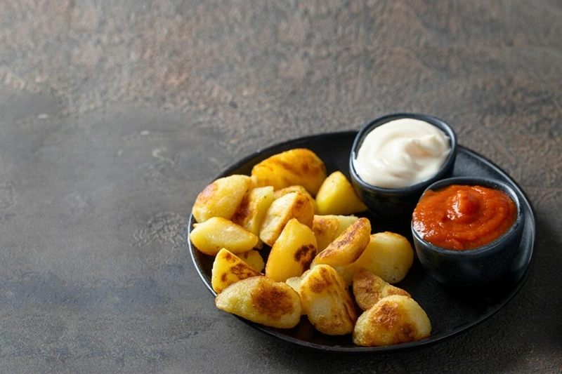 Plated patatas bravas as New Year's Eve dinner party ideas.