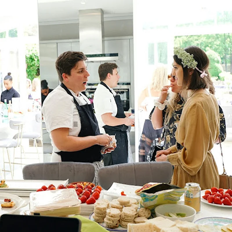 Women discussing catering for hen party with a chef.
