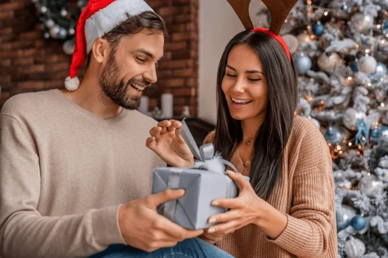 A man offering his Christmas present for girlfriend.