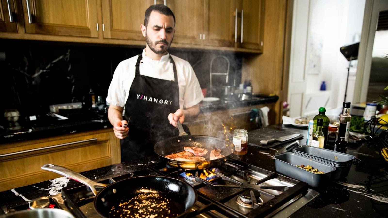 Yhangry chef searing salmon for an intimate private dining event.