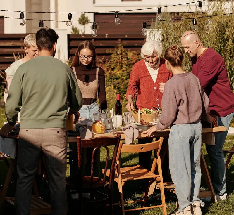 Guests gathered around a set table at a make-ahead summer dinner party.