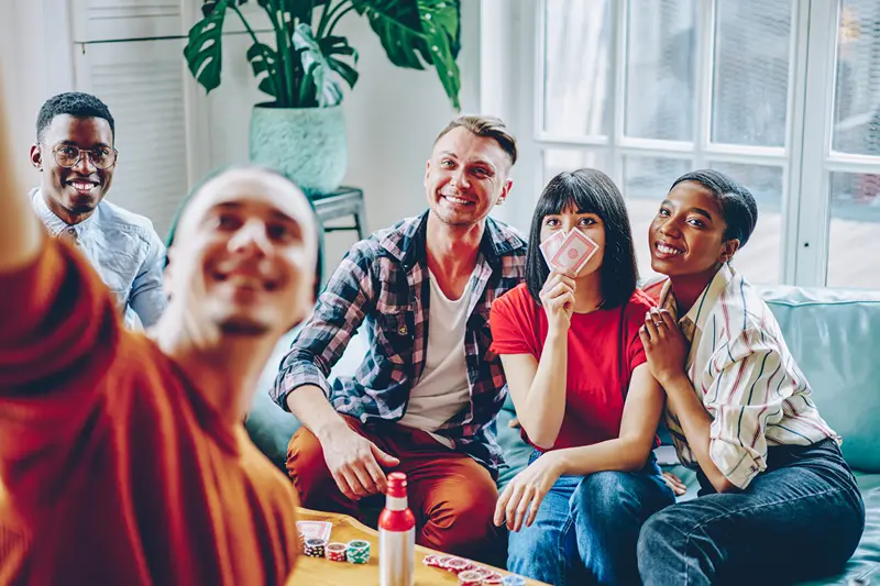 Friends taking a selfie on game night, showing things to do for 21st birthday UK.