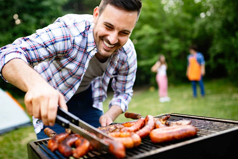 Man grilling at a BBQ, showing what to do for 21st birthday.