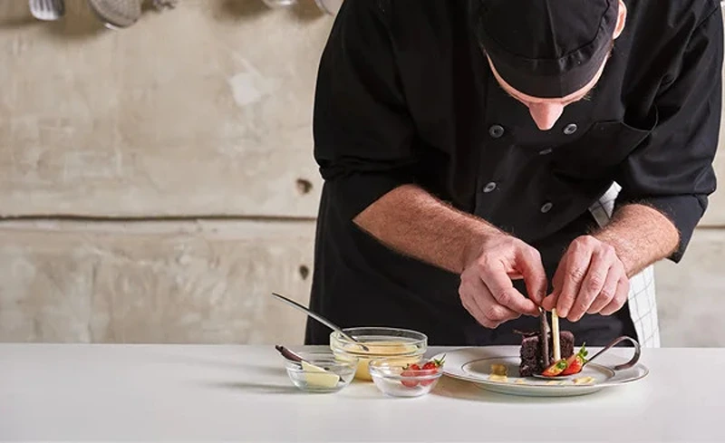 A chef working on a private jet catering menu.