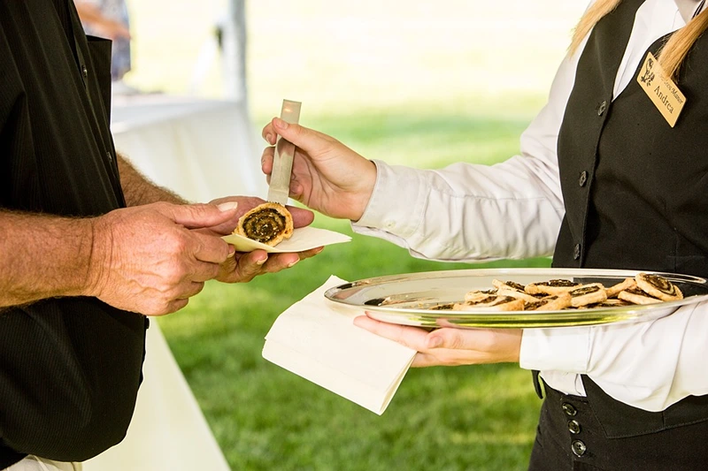 Servers catering an office party with food service.